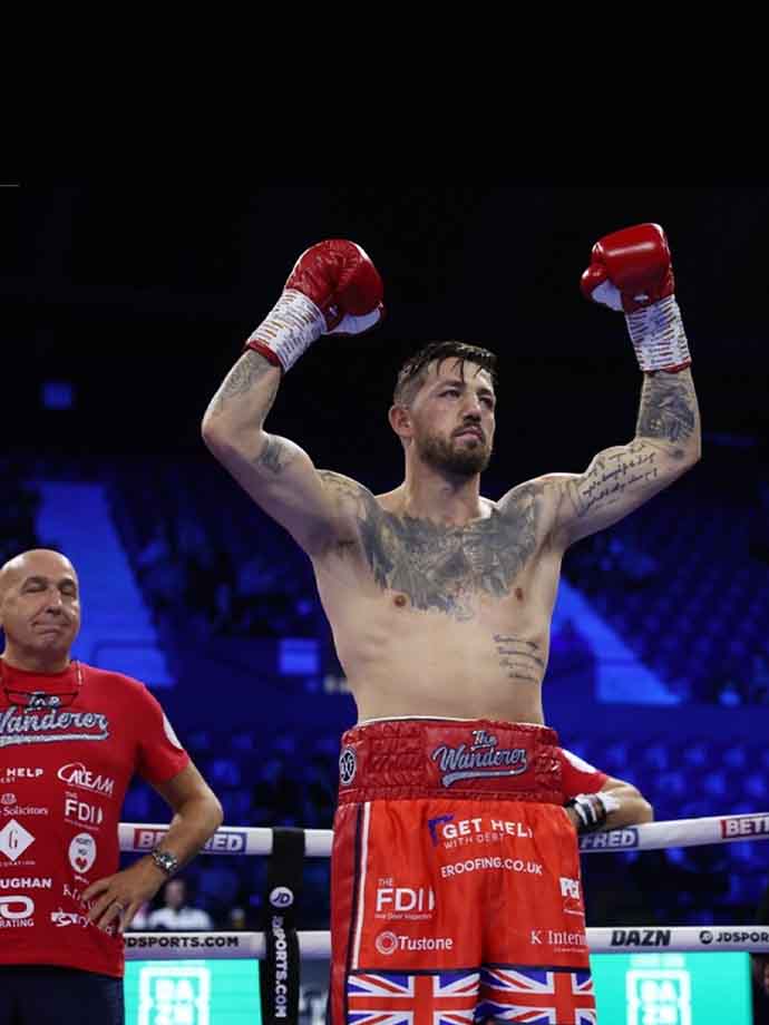 Jordan Reynolds raising his arms in the boxing ring