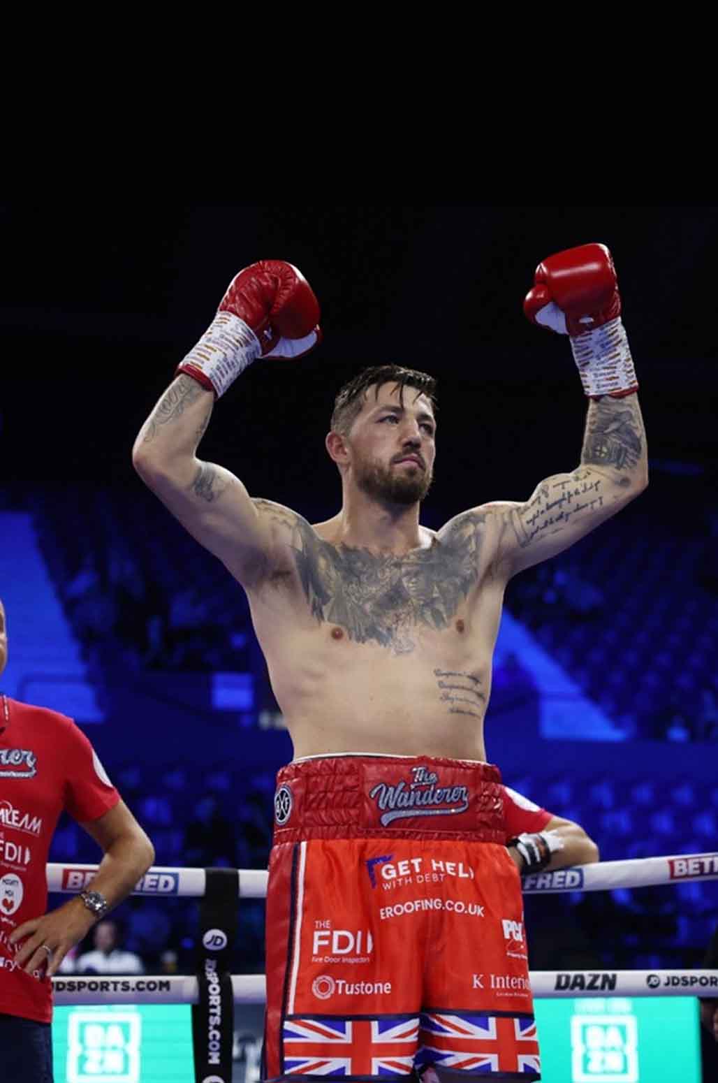 Jordan Reynolds raising his arms in the boxing ring